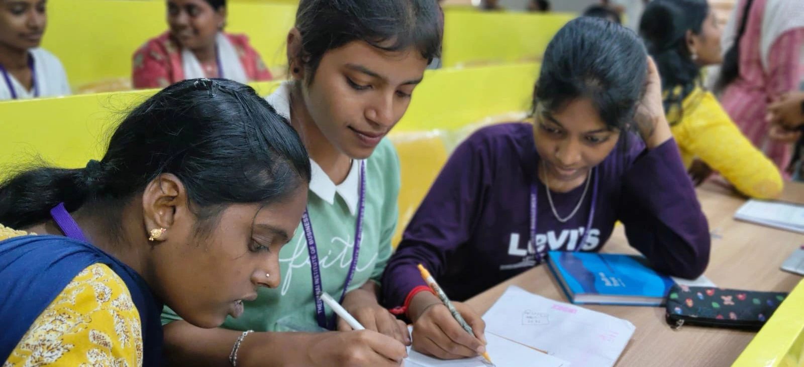 Three students working together on a poster during Ad Masters